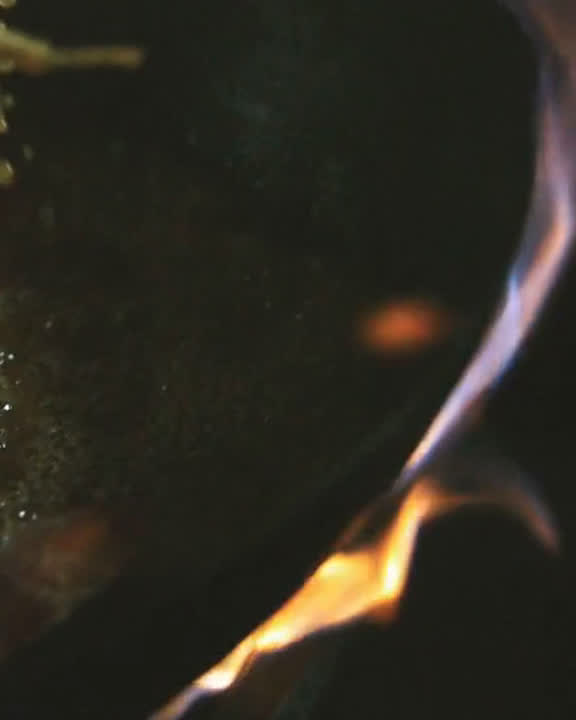 Wokad mat flamberas över öppen låga i ett restaurangkök – bildspråket från Lee Baguettes Serveo-sajt.